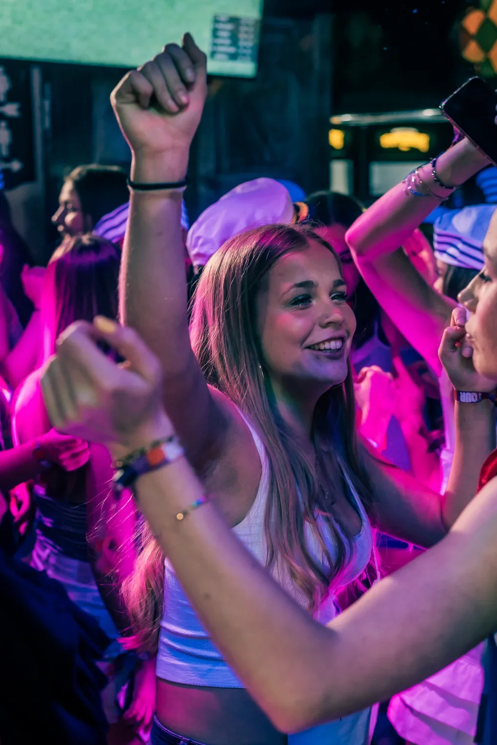 Young women dancing together at a nightclub on a group trip.