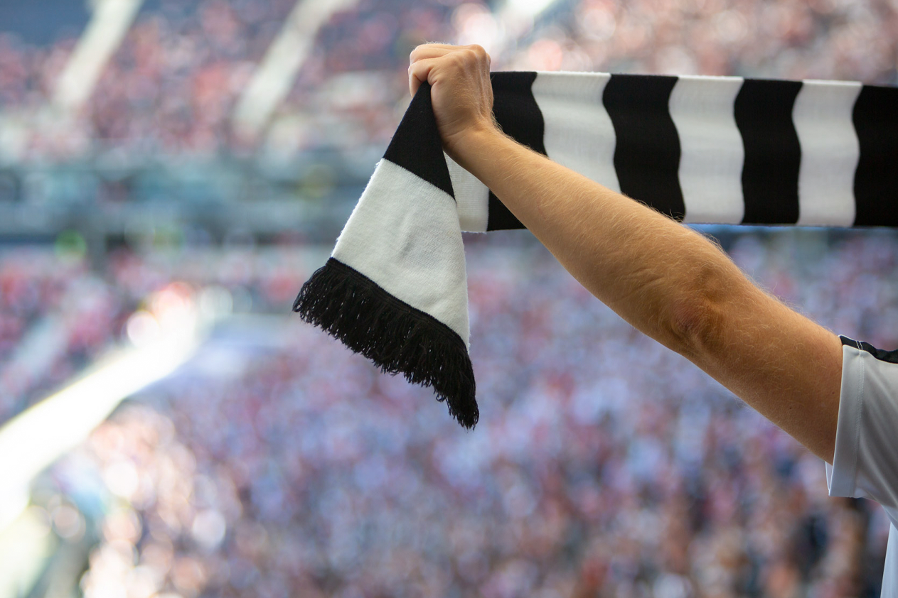 Fan von Eintracht Frankfurt winkt mit seinem Schal während eines Fußballspiels