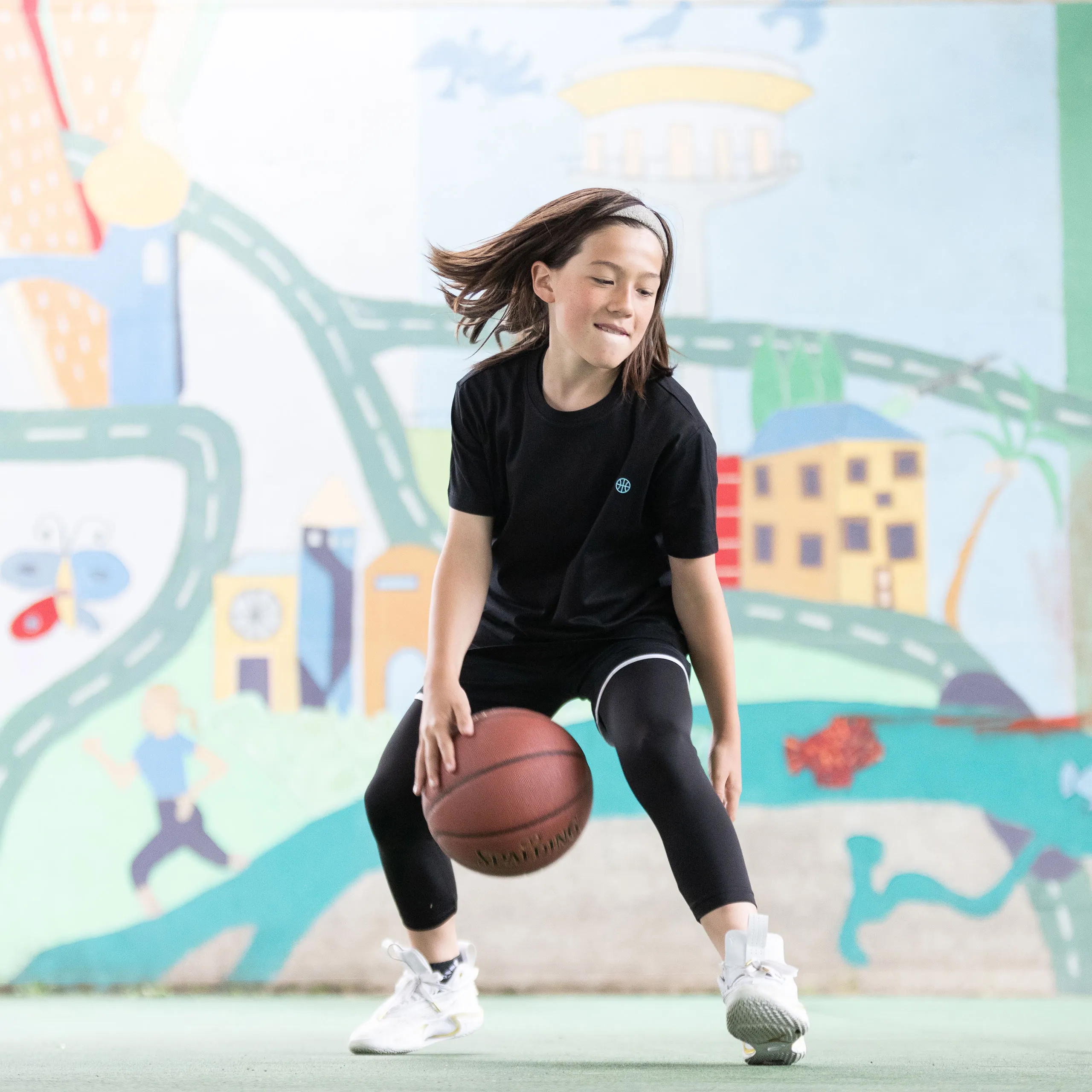 Mädchen spielt Basketball im neuen Dress der Veolia Towers Hamburg