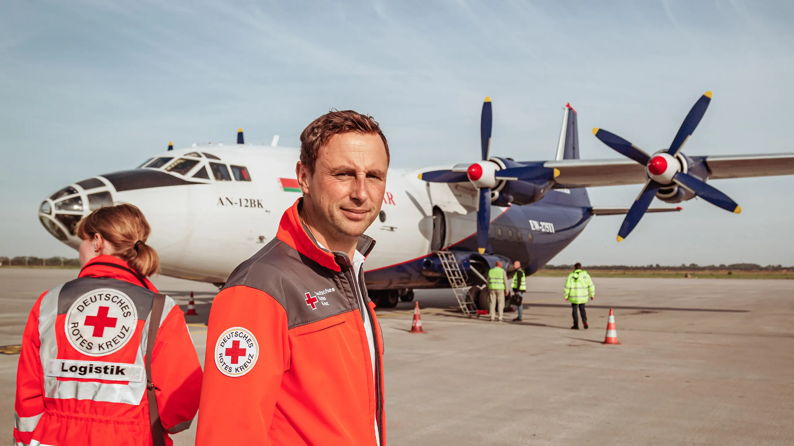 Ein Helfer des Deutschen Roten Kreuzes auf einem Flugplatz