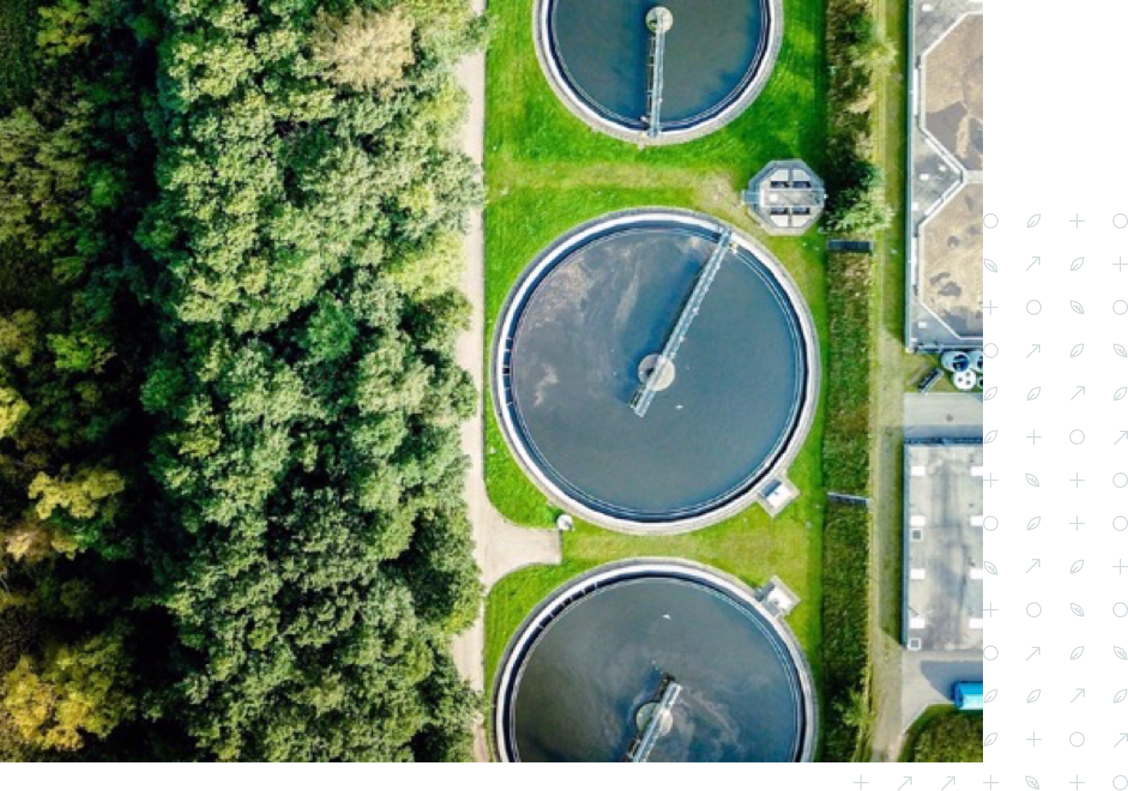 Aerial view of three circular water treatment tanks next to green trees and buildings.