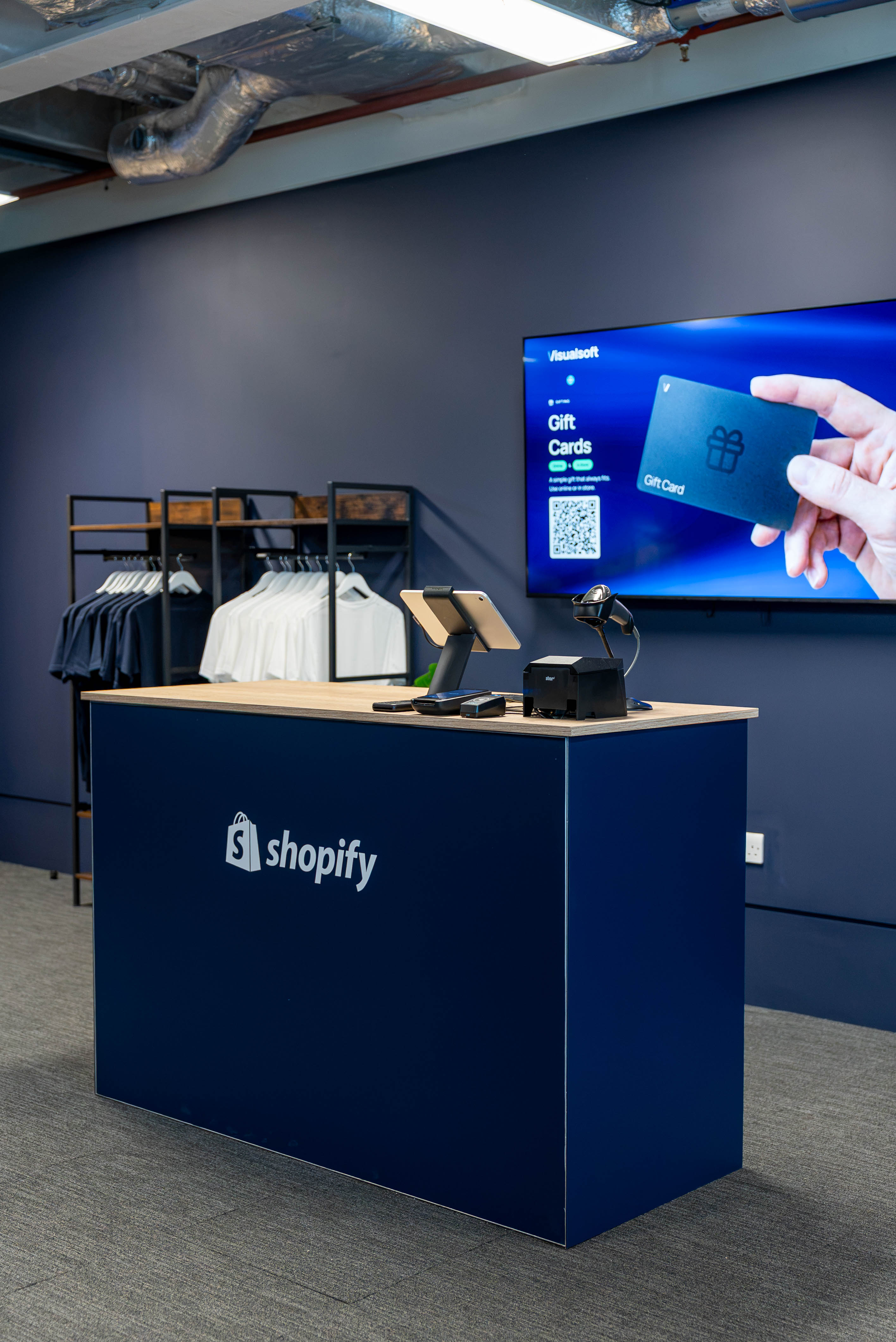 The Shopify POS till with digital signage behind it
