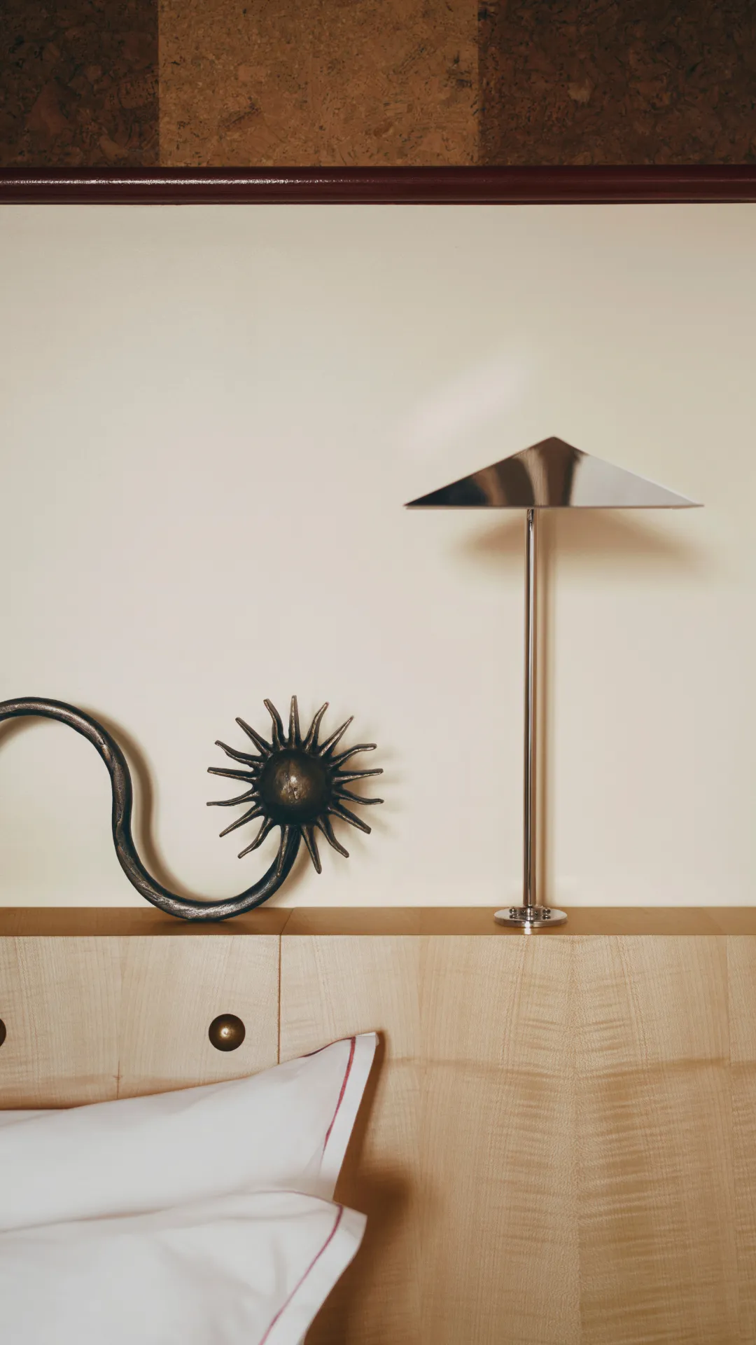 Chrome lamp and sun ornament on a wooden headboard, Hotel Luxia in the press in Montmartre
