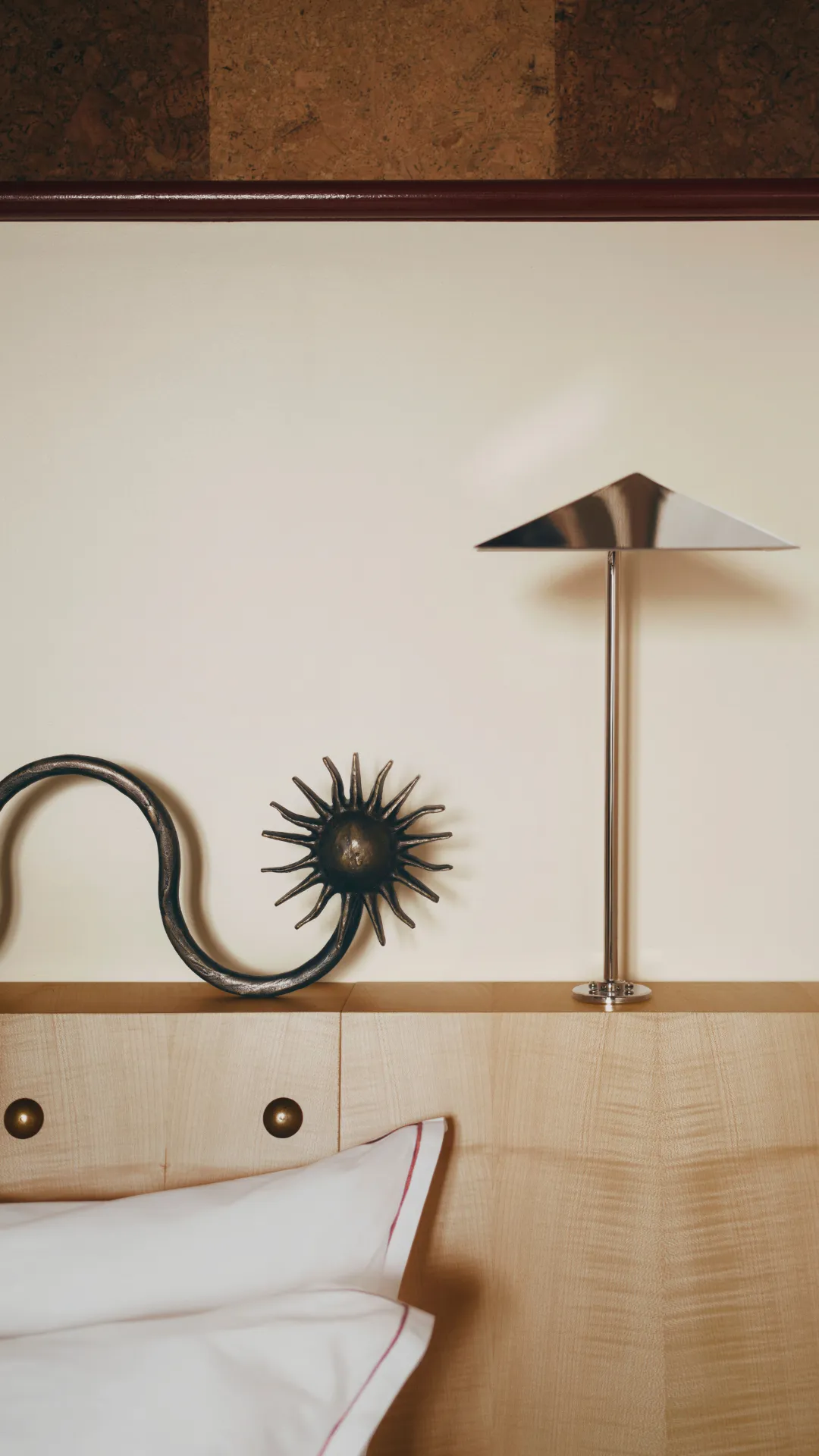 Chrome lamp on a wooden headboard in a Hotel Luxia room in Montmartre