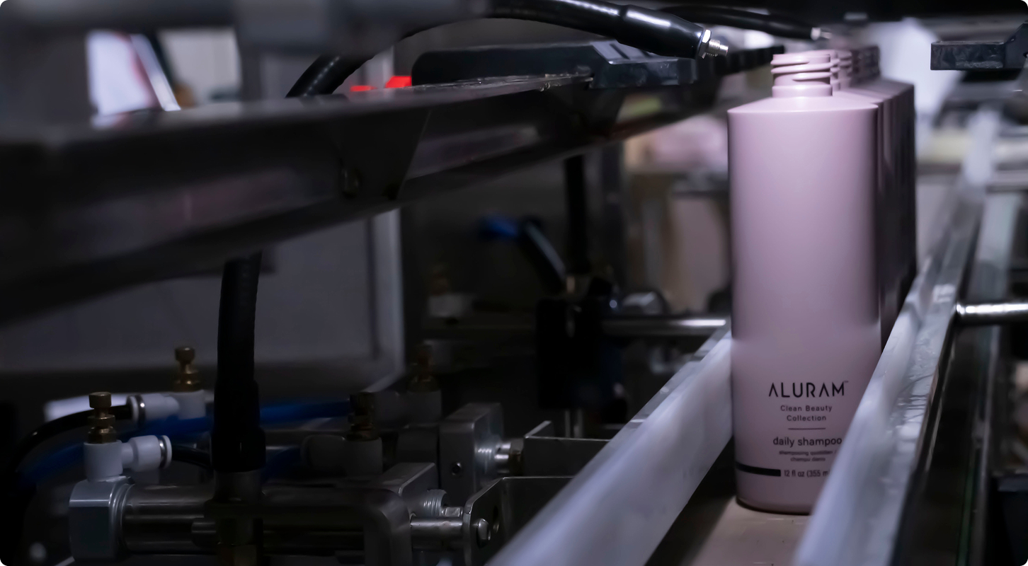 Aluram daily shampoo bottle on a filling line inside the Creative Beauty Brands manufacturing facility