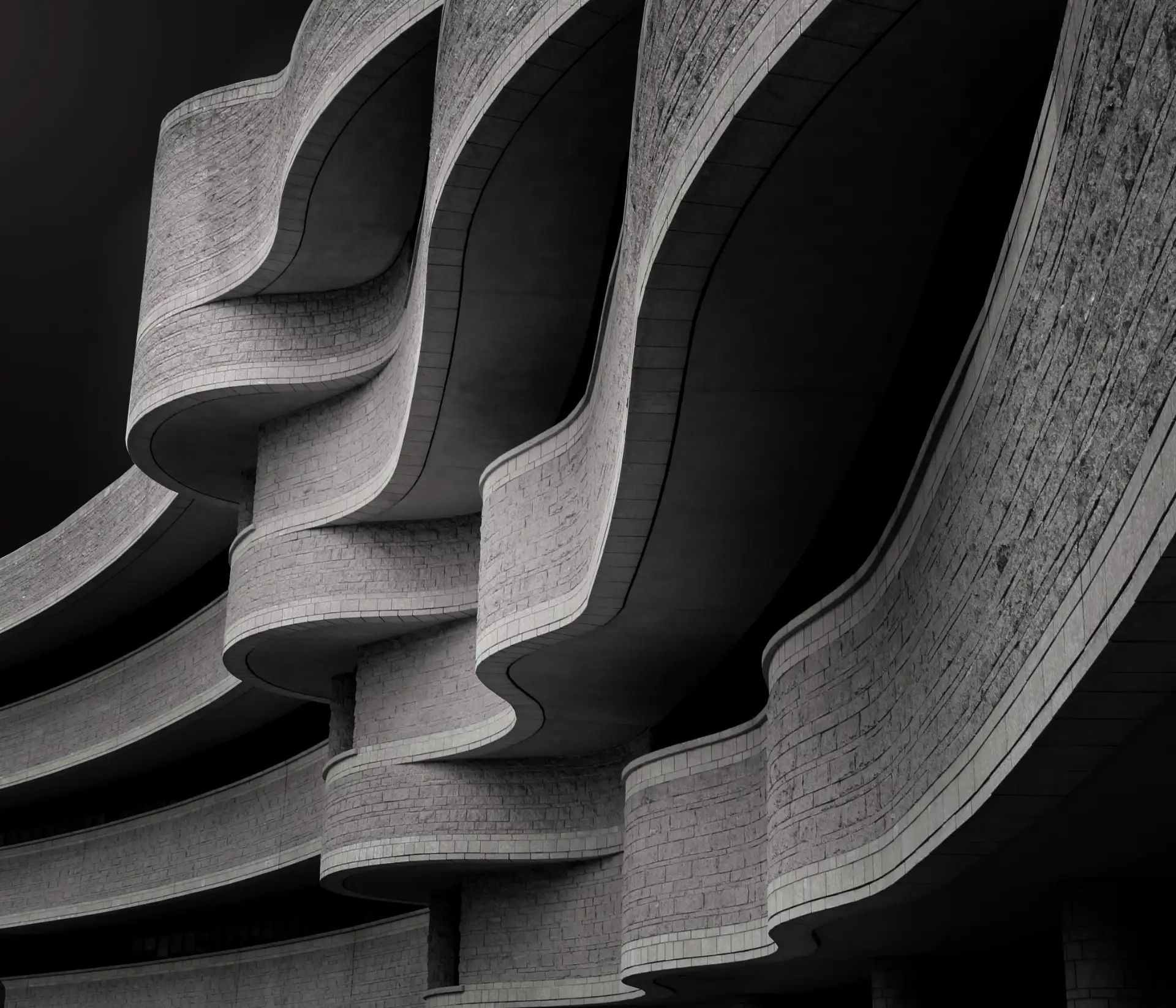 Nahaufnahme einer modernen brutalistischen Architektur mit gewellten, steinernen Balkonen.