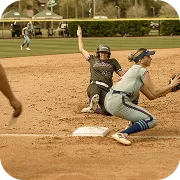 Softball player sliding into base as opponent in catcher's gear attempts to tag her out.