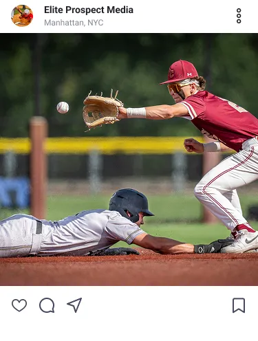 Baseball player in white slides to base as player in red reaches to catch the ball.