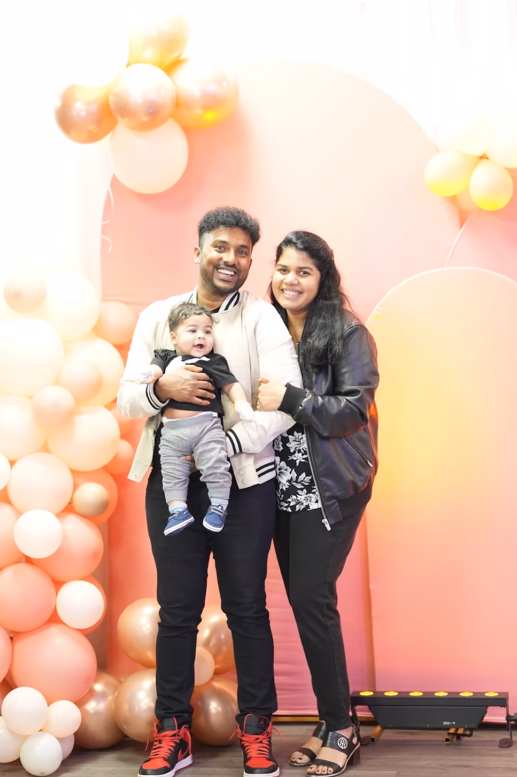 Hue Church family standing in front of a balloon backdrop
