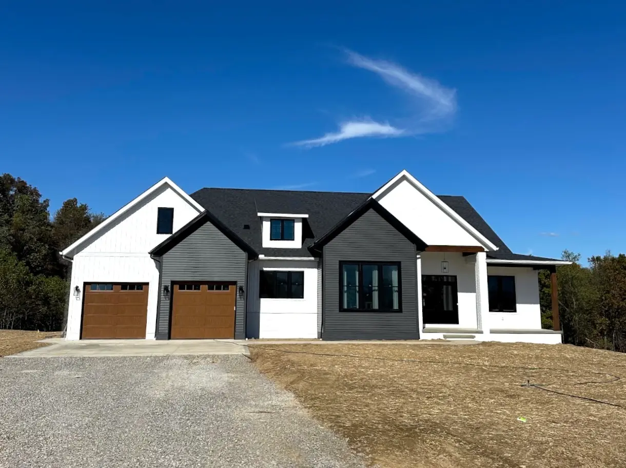 white and gray siding home with two car garage
