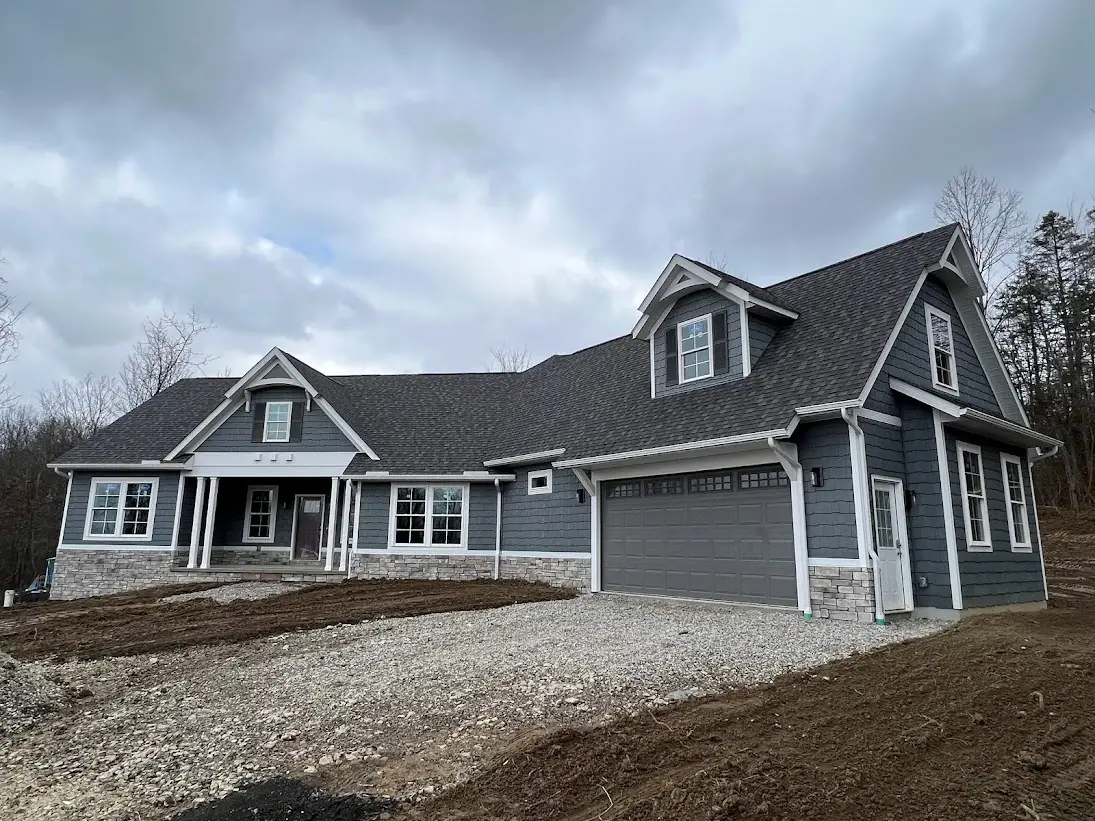 long two story home with gravel driveway
