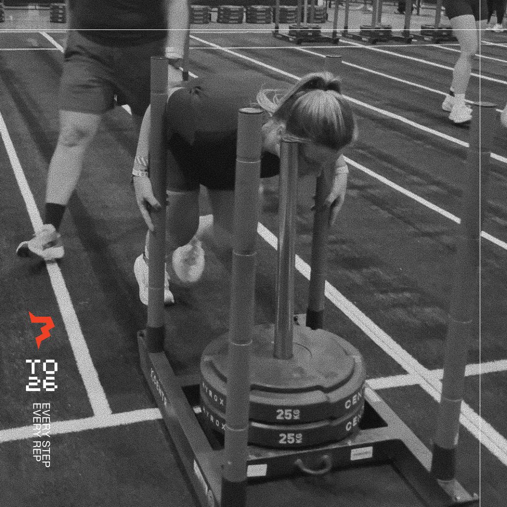 Woman pushing sled at HYROX