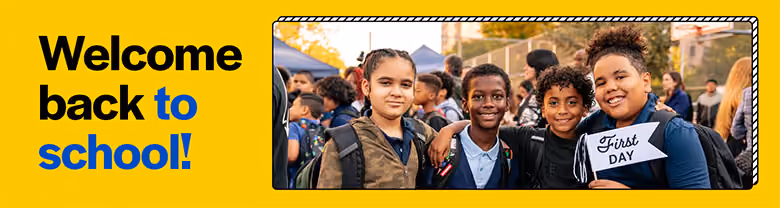 Four smiling students with backpacks on first day of school