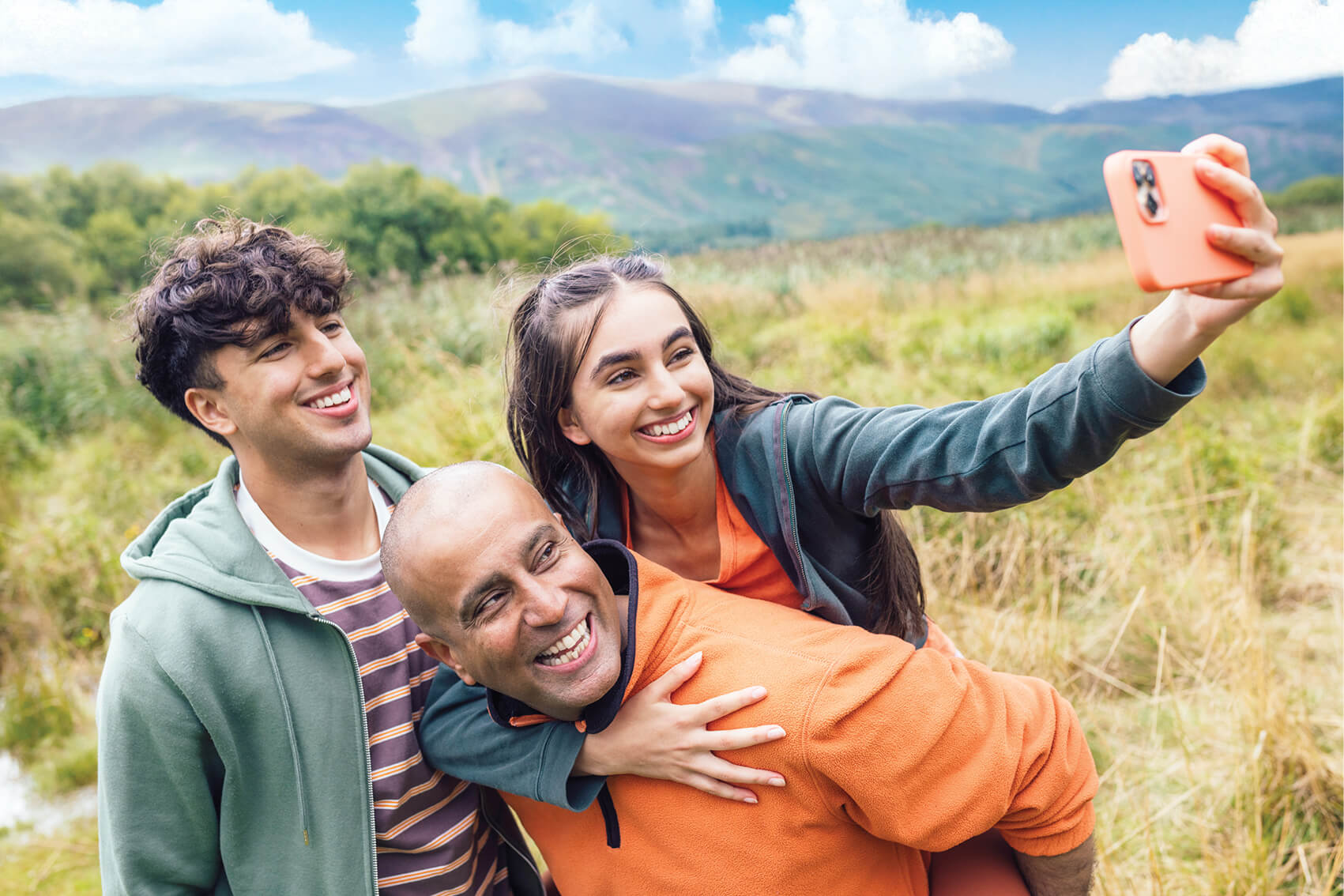 A family out for a hike, smiling and posing for a picture