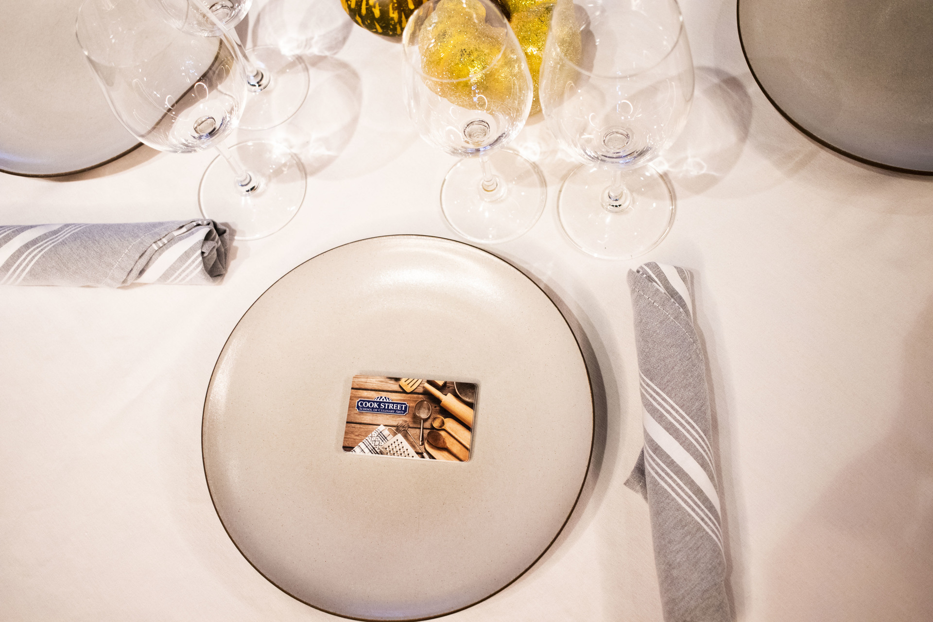 Cook Street gift card on a plate set for two with wine glasses