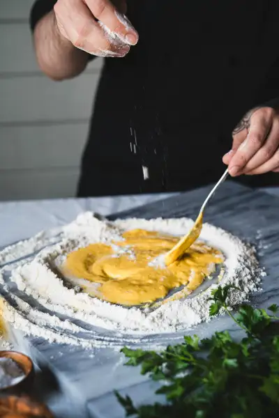 Chef mixing pasta dough in a flour well
