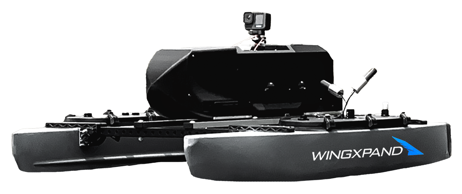 Black dual-hull drone boat with GoPro camera and WingXPAND logo on the side.
