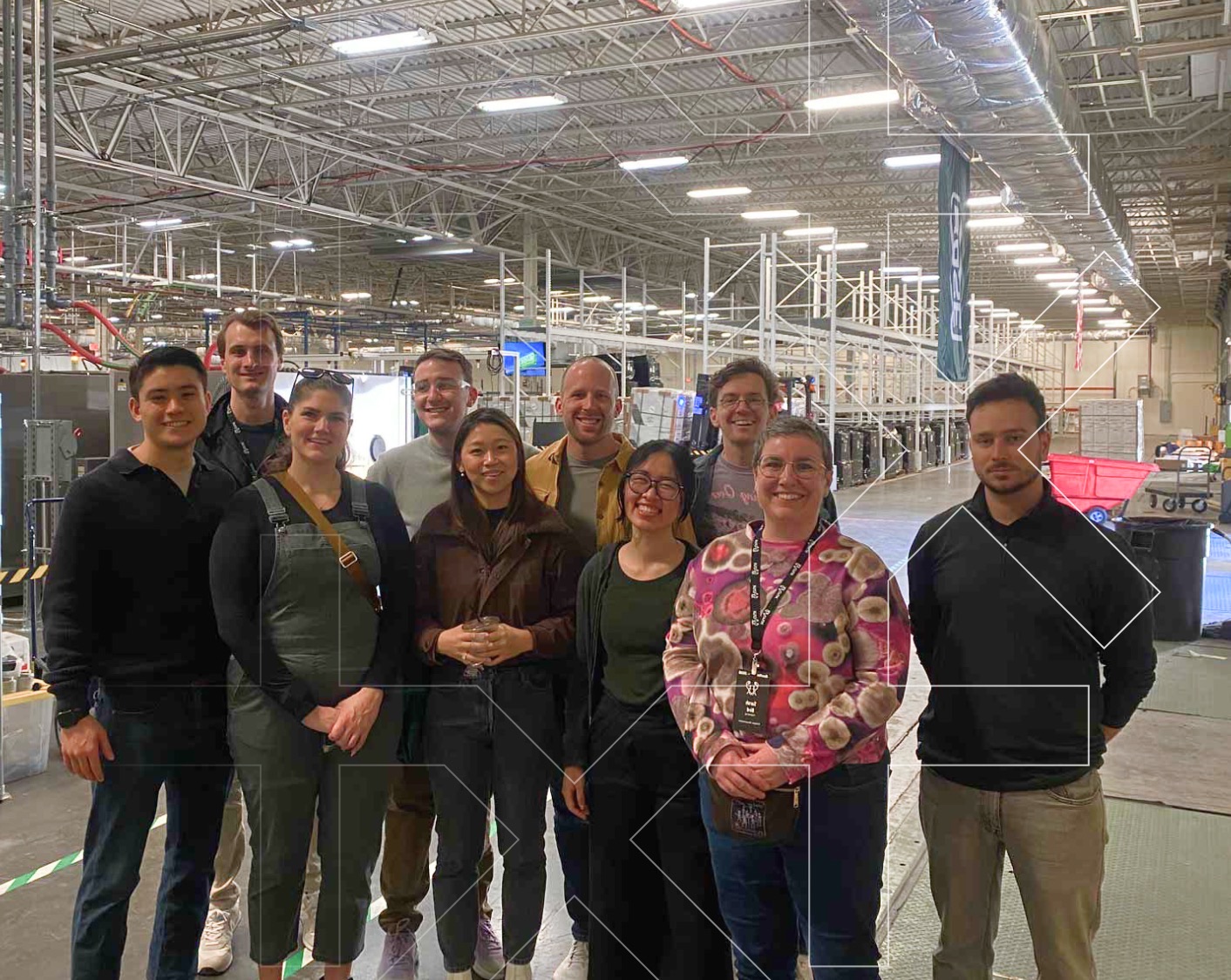 Crux team standing together in a manufacturing facility