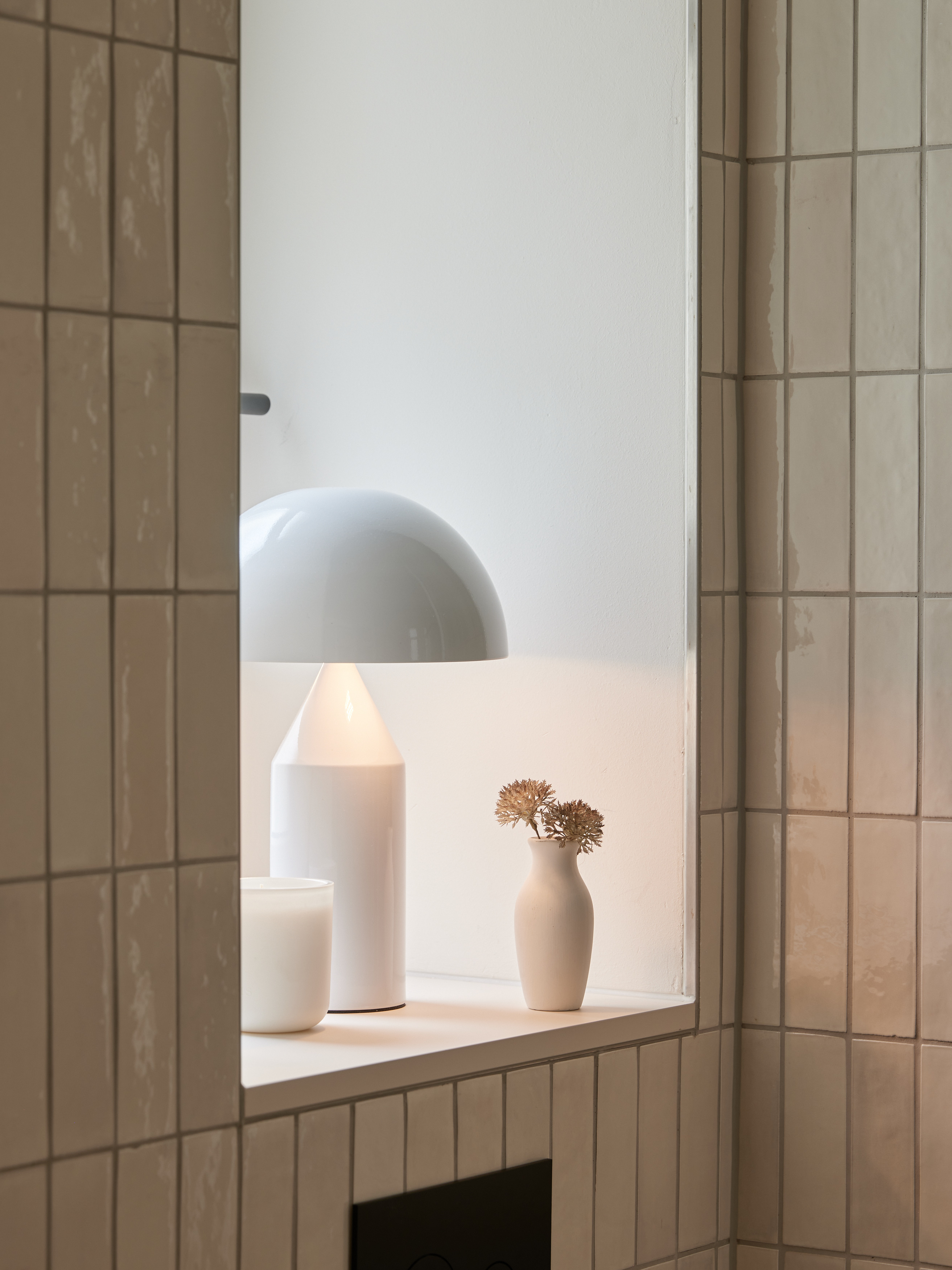 Fensterbank-Detail mit Leuchte, Kerze und Vase mit Trockenblumen, warmes Licht