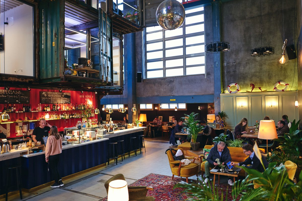 Restaurant und Bar im Kraftwerk Selnau des Impact Hub Zürich mit warmen Lichtinseln und industrieller Hallenarchitektur