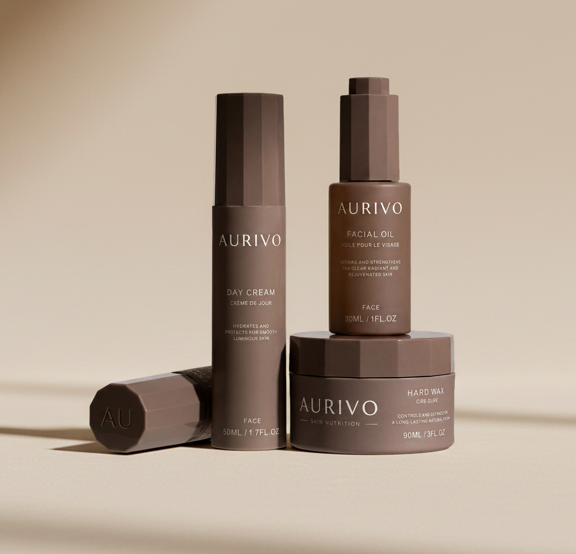 Set of three beige-brown cosmetic products labeled as Lehnberger Stafsing skincare on a glass surface with a plain light background.