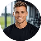 Lächelnder Mann im Fitnessstudio vor großen Fenstern mit Blick auf grüne Wiese, trägt schwarzes T-Shirt.