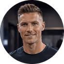 Lächelnder Mann mit kurzem Haar in Sportkleidung in einem Fitnessstudio.
