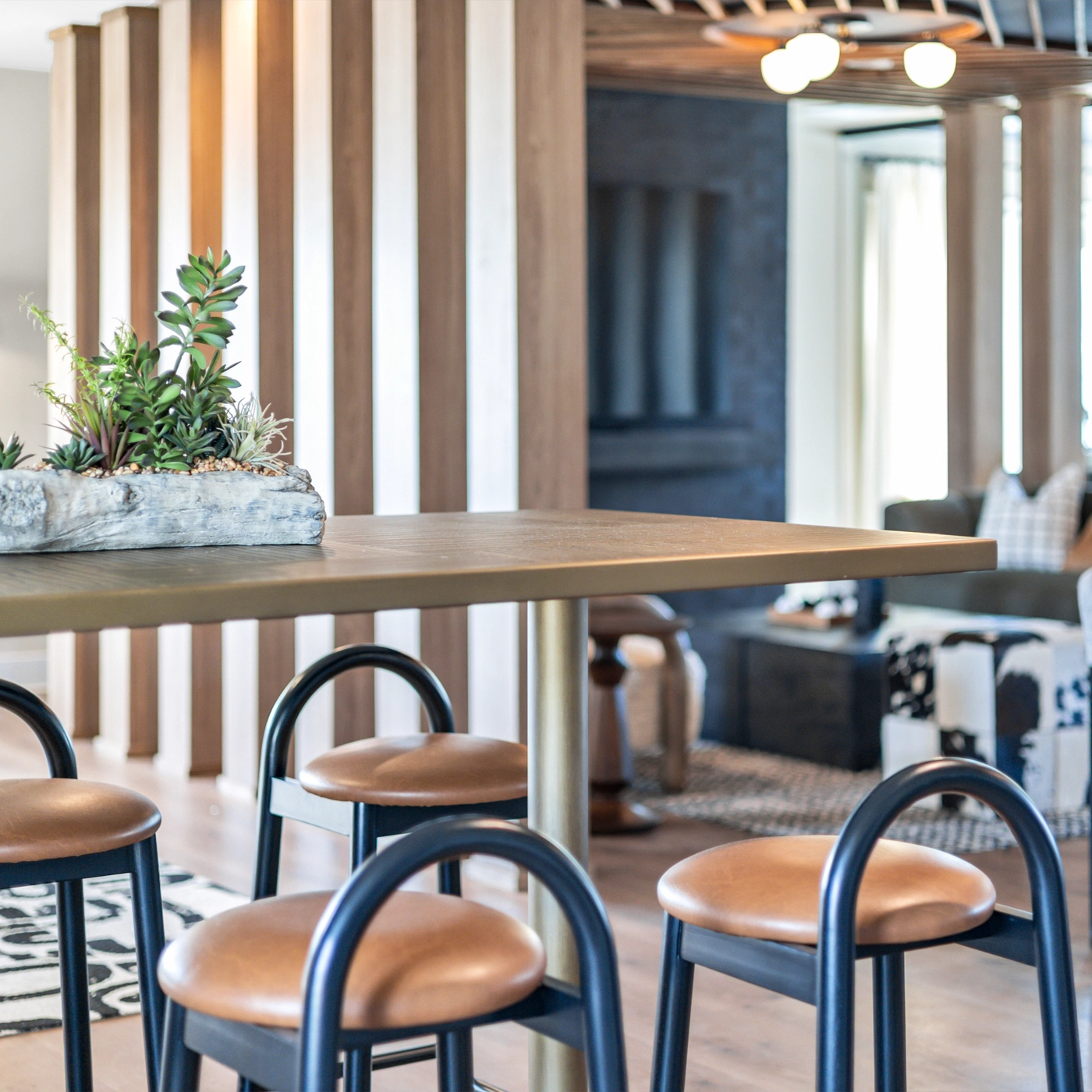 Bar-height table with leather stools in a resident lounge