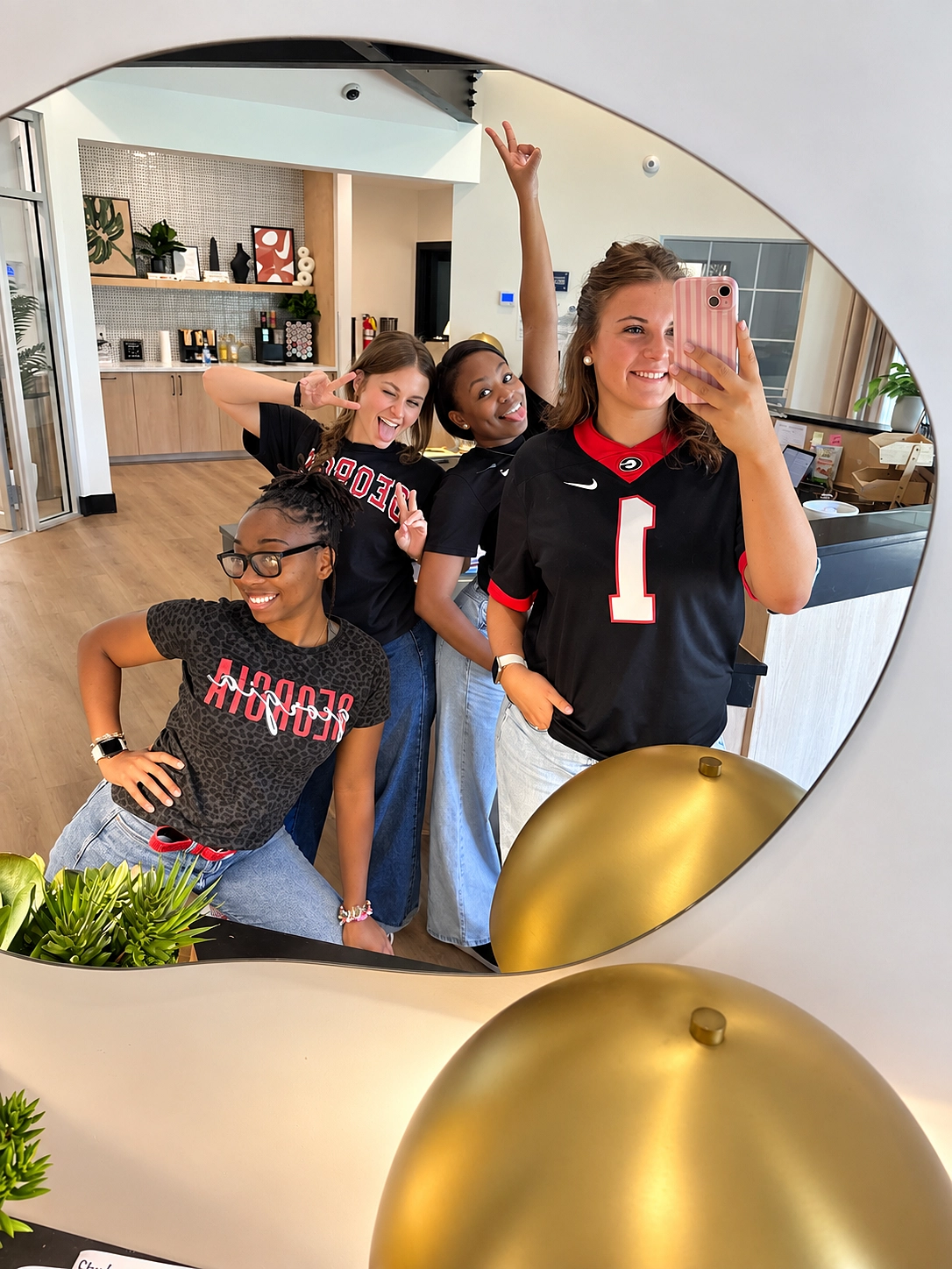 Team members taking a mirror selfie in game day jerseys