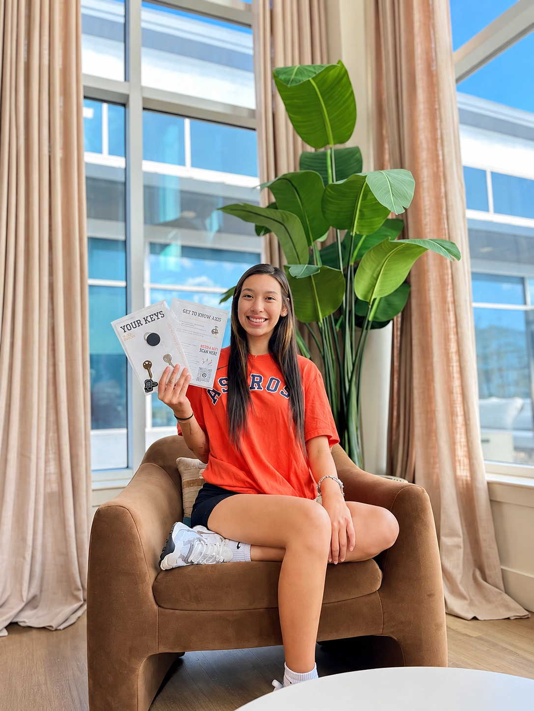 Resident holding her new keys in a sunny lounge