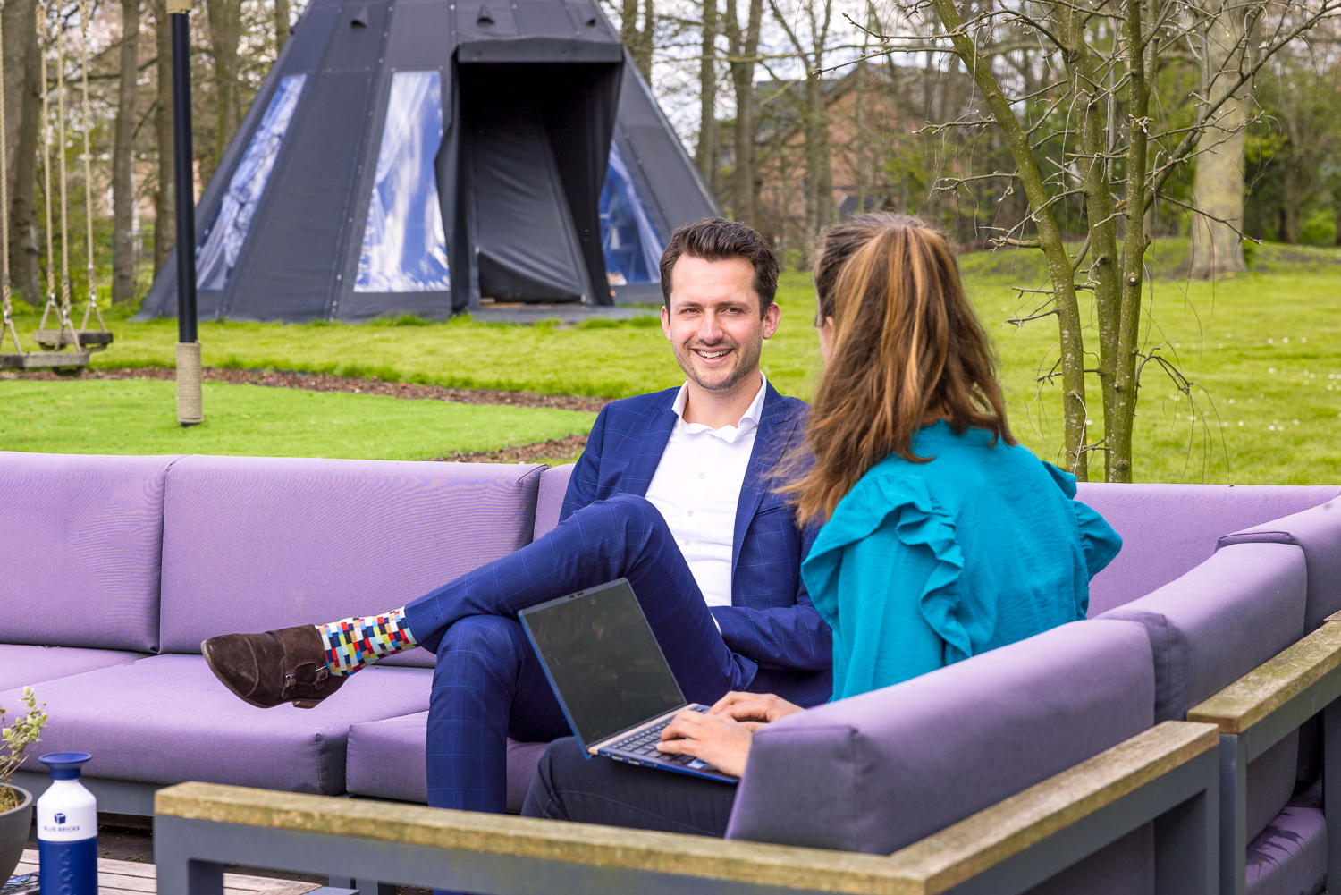 Twee collega's wandelen langs het kantoorgebouw op de campus