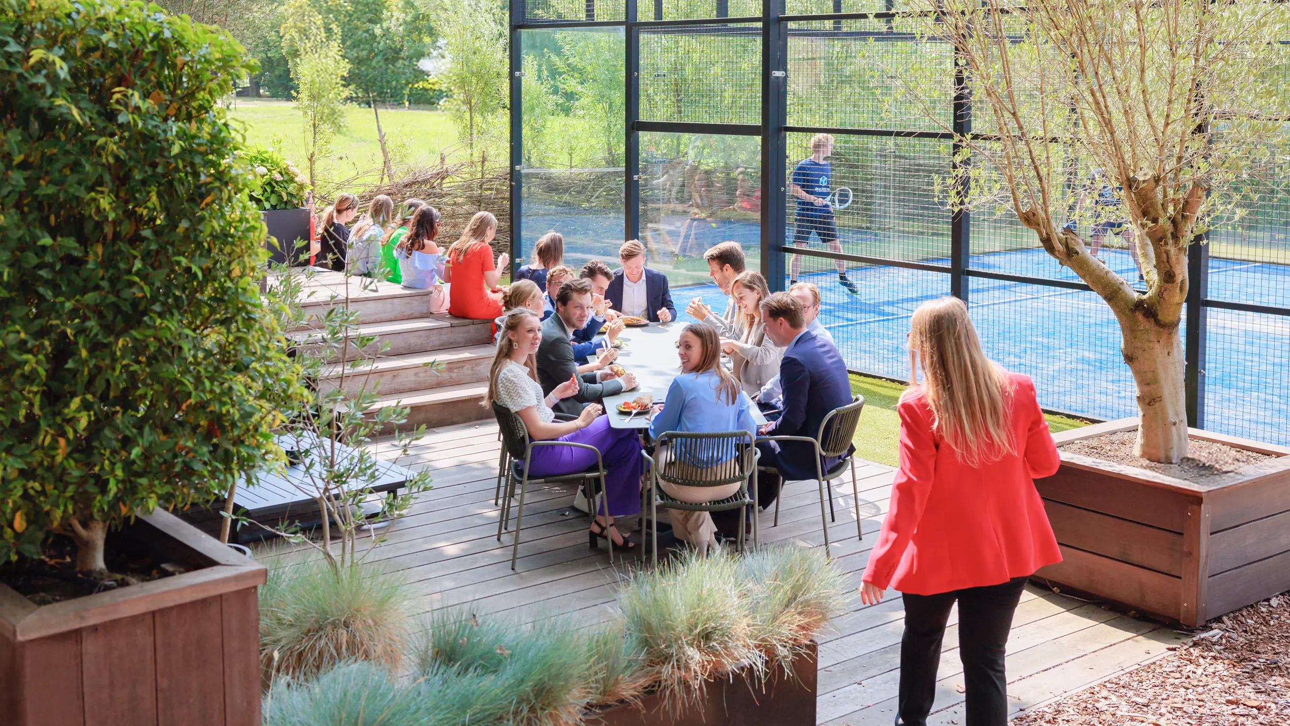 Gezamenlijke lunch op het terras naast de padelbaan van de Blue Bricks campus — placeholder, beeld van de kantine volgt van de klant