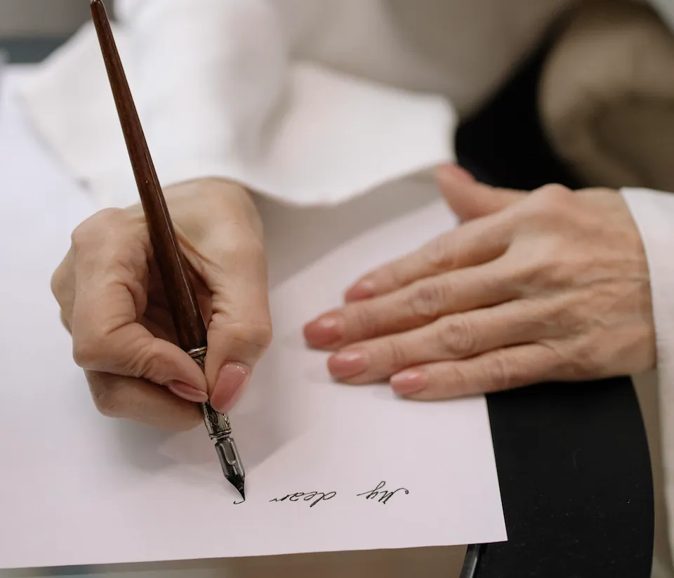 Hand writing a personal note in cursive with a fountain pen for a gifted Giftada membership