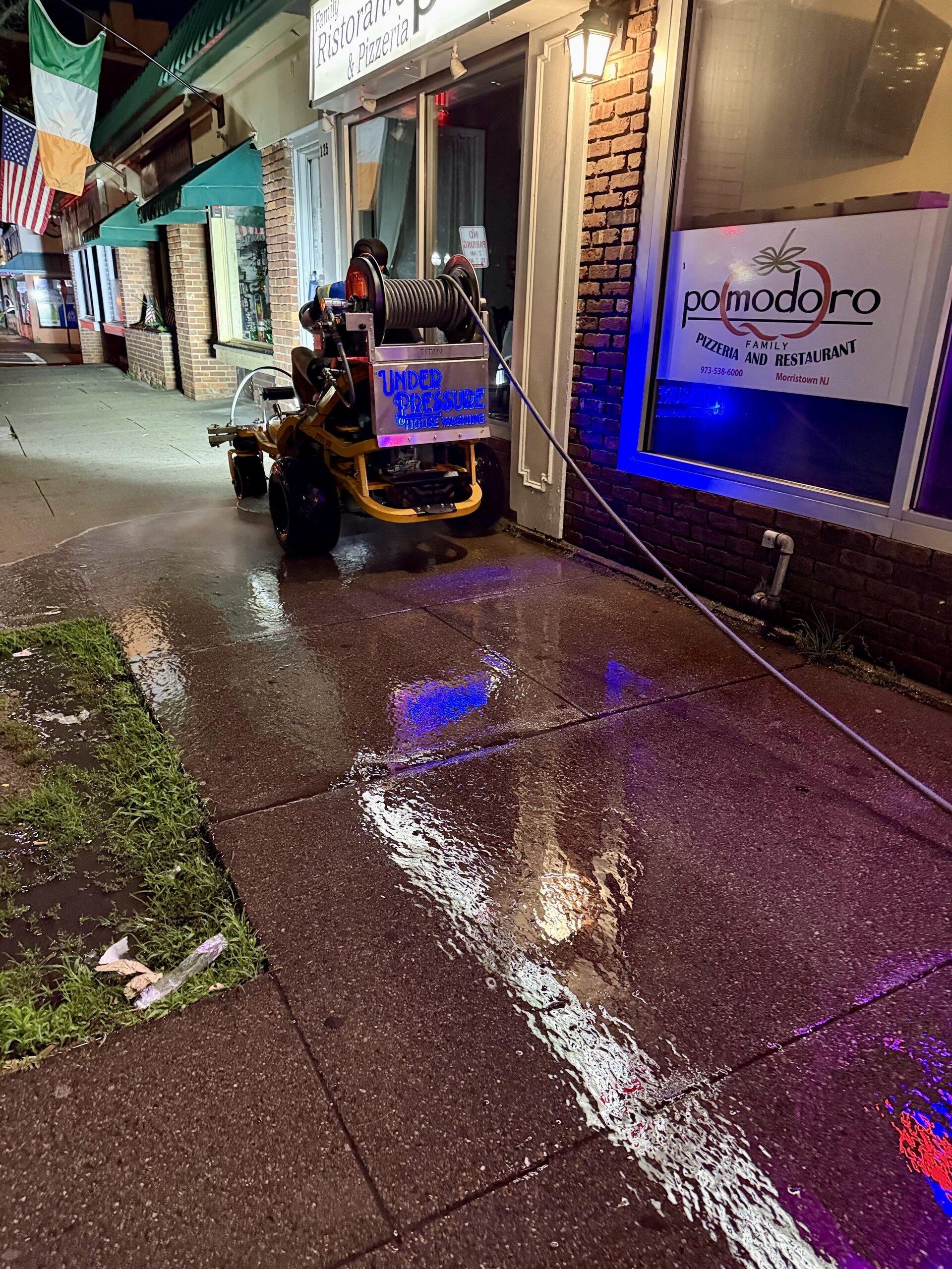 Concrete cleaning at a New Jersey storefront at night