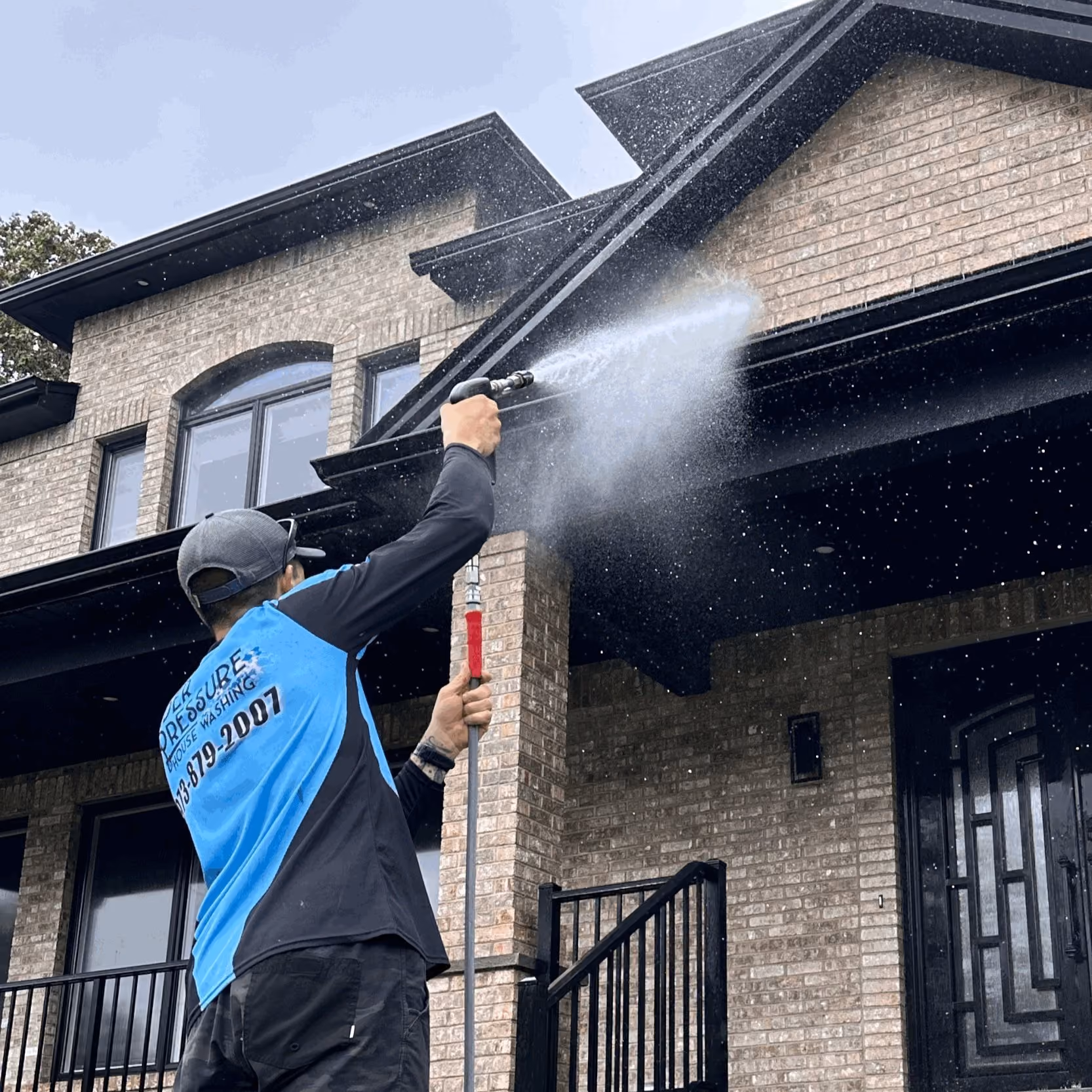 Technician soft washing a house exterior in New Jersey