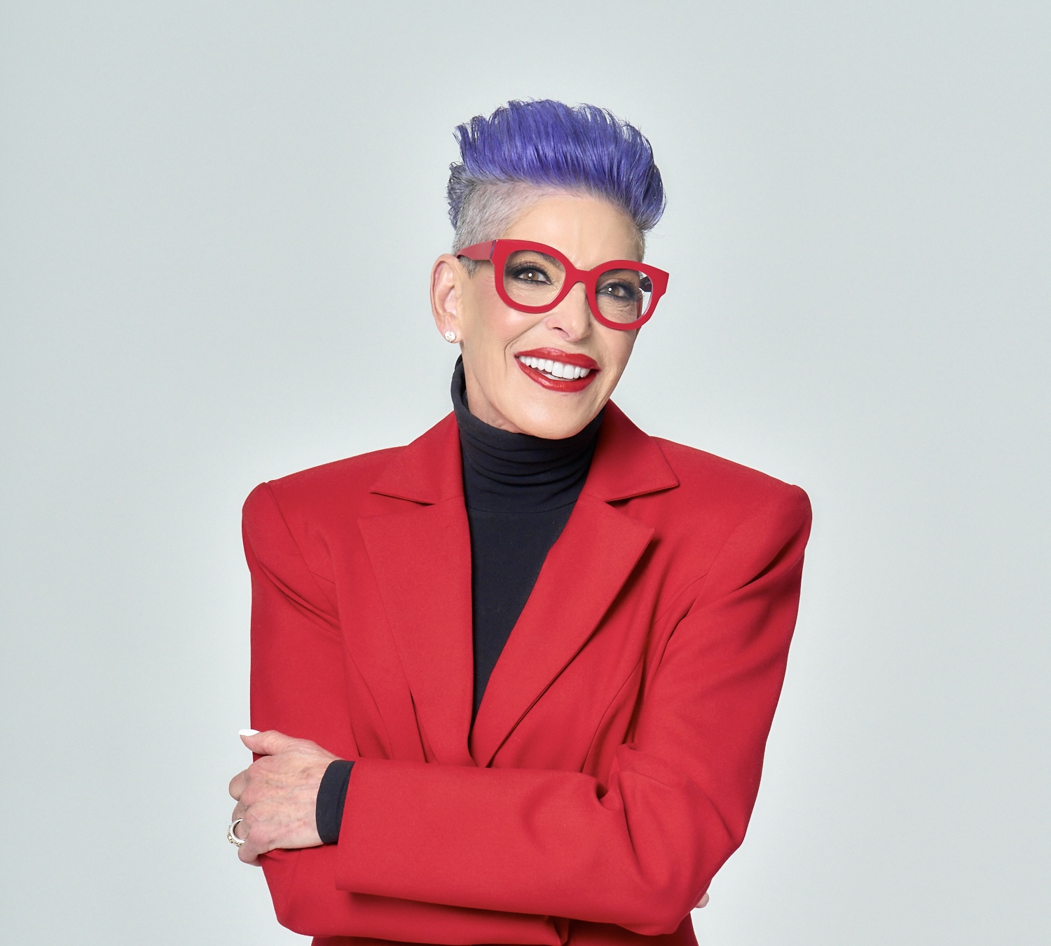 Barbra Jo Batterman in a red blazer and red glasses with signature purple hair