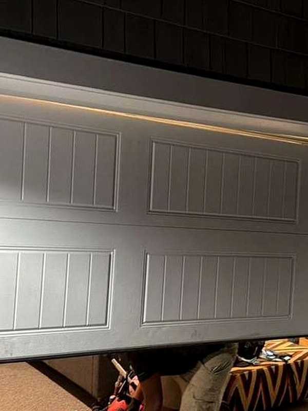 Garage door hanging off its track and sitting crooked before repair in Manhattan Beach