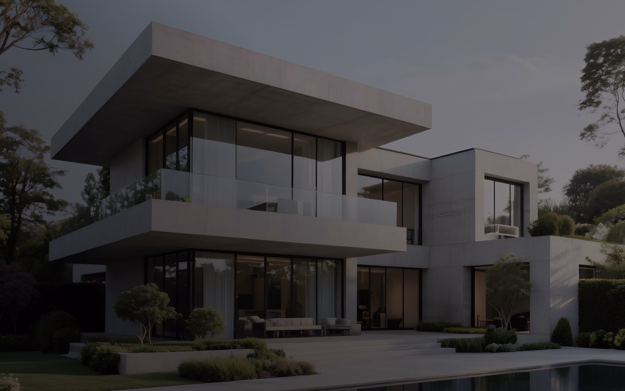 Modern two-story house with large glass windows, balcony, outdoor seating, and landscaping.