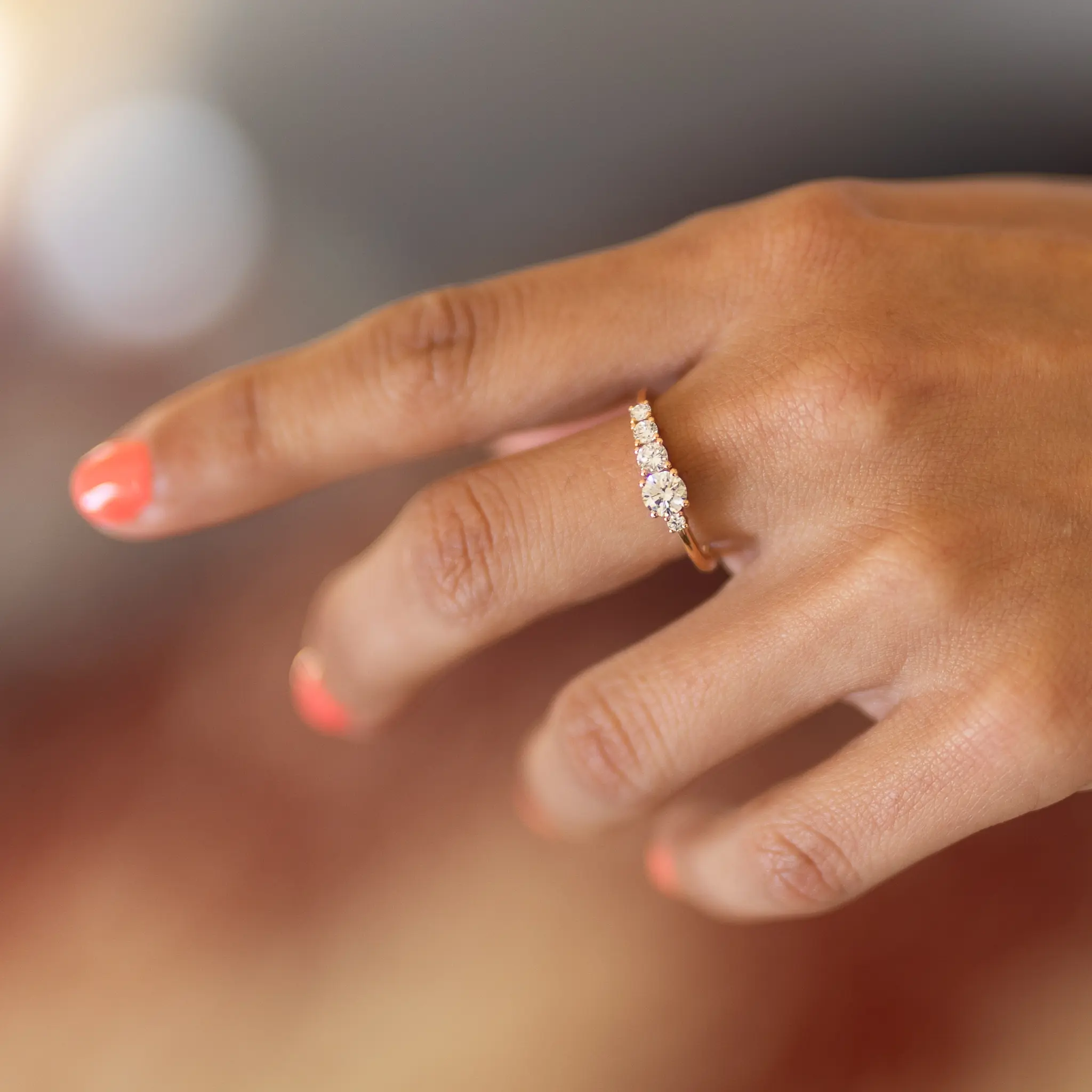 Bague en or rose sertie de diamants portee a la main