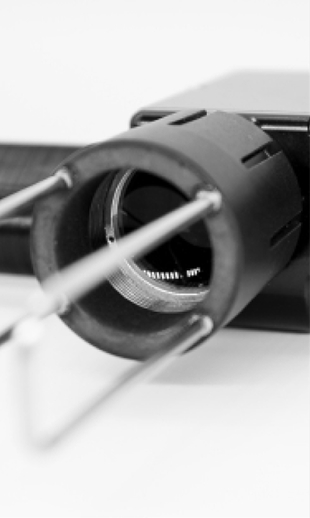 Nahaufnahme eines medizinischen Geräts mit einer Röhre und Metallstiften, unscharfer Hintergrund.