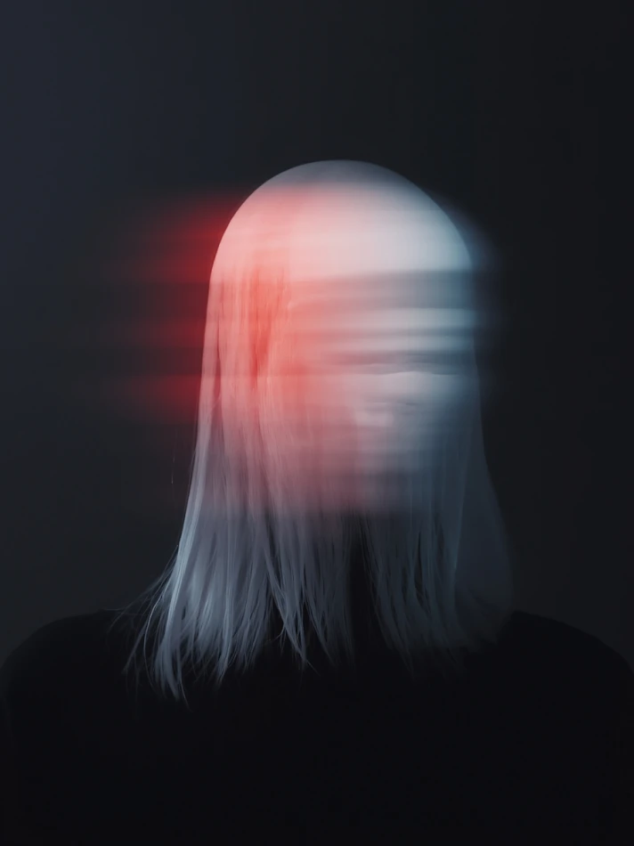 Mysterious figure with glowing blurred face.