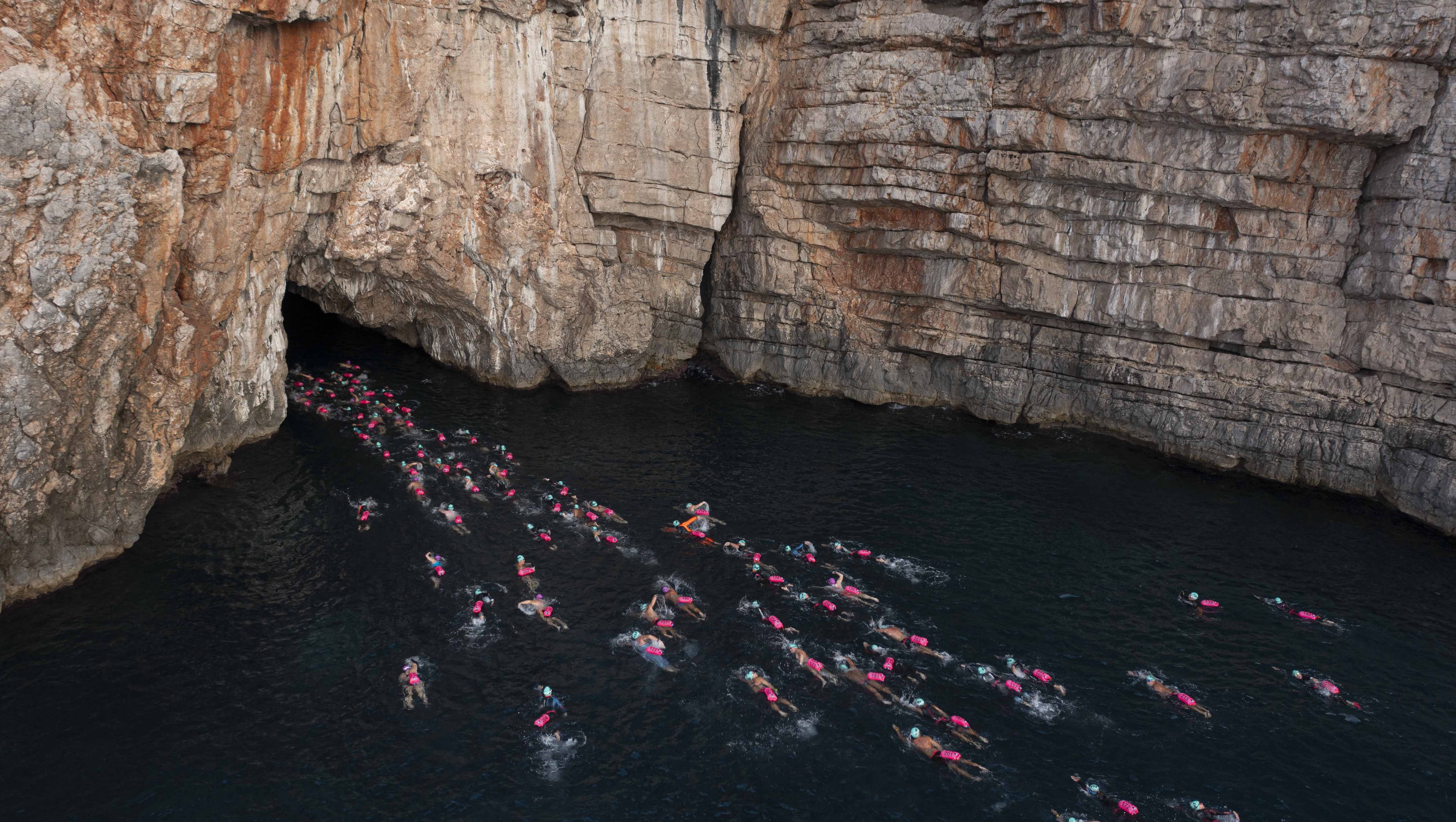 UltraSwim 33.3 swimmers from above entering the blue cave, Montenegro