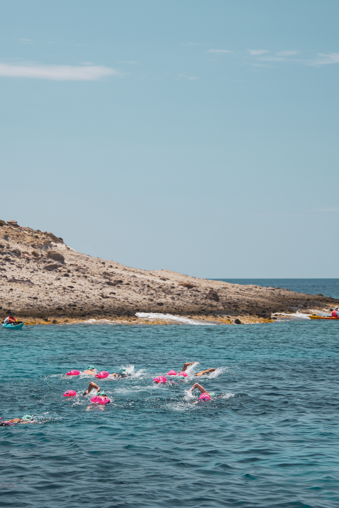 UltraSwim 33.3 Milos, swimmers rounding a headland