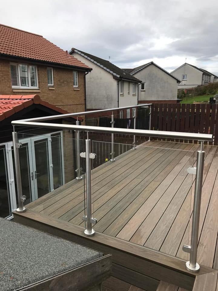 Glass balustrade with steel posts along a raised timber garden decking