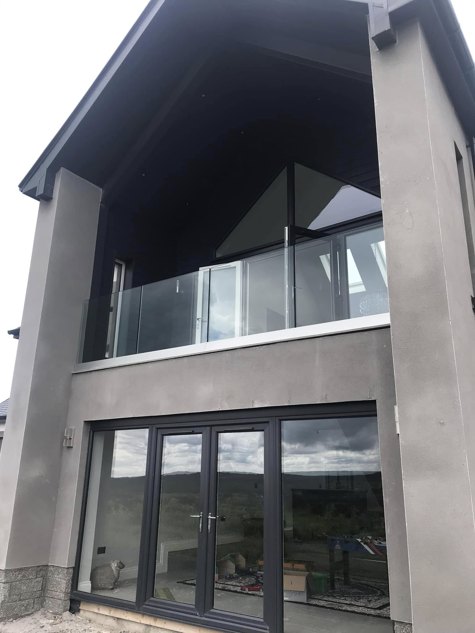 Glass balcony balustrade above bifold doors on a modern two storey house