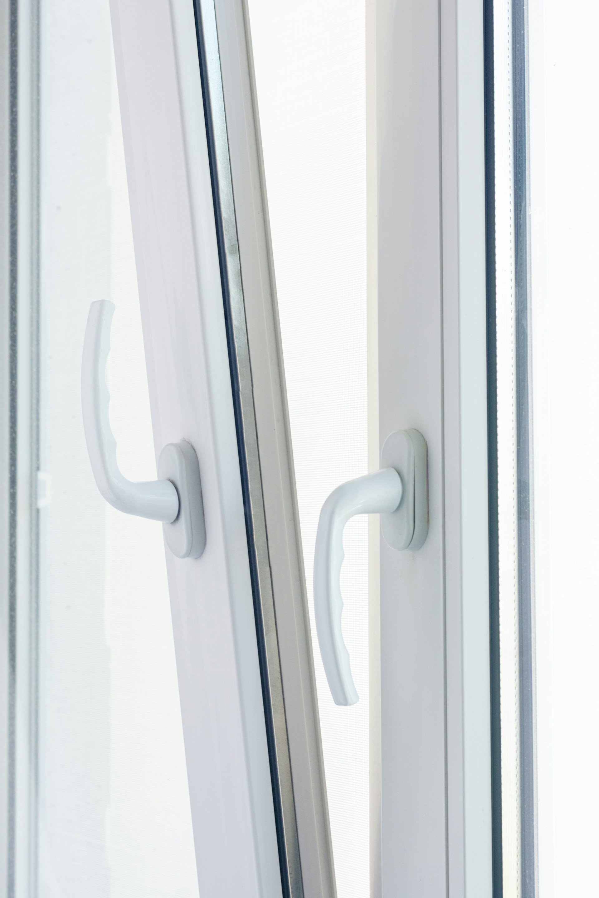 Stock photo, close-up of white uPVC window handles on double glazing