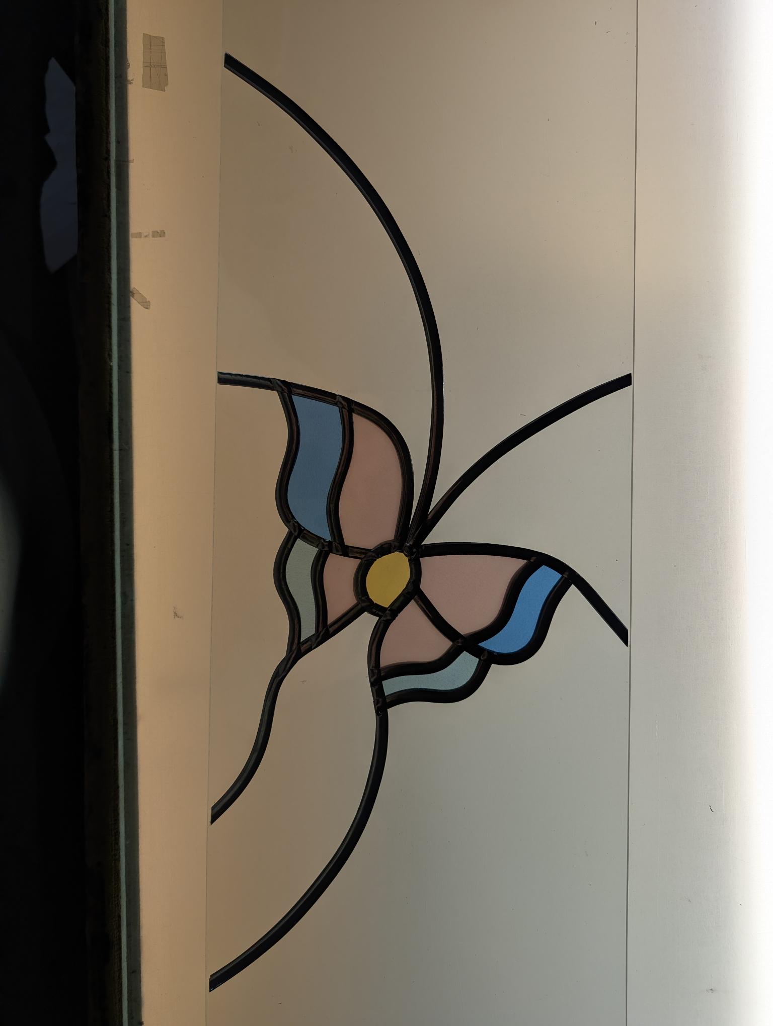Decorative leadwork forming a flower shape on a frosted glass door panel