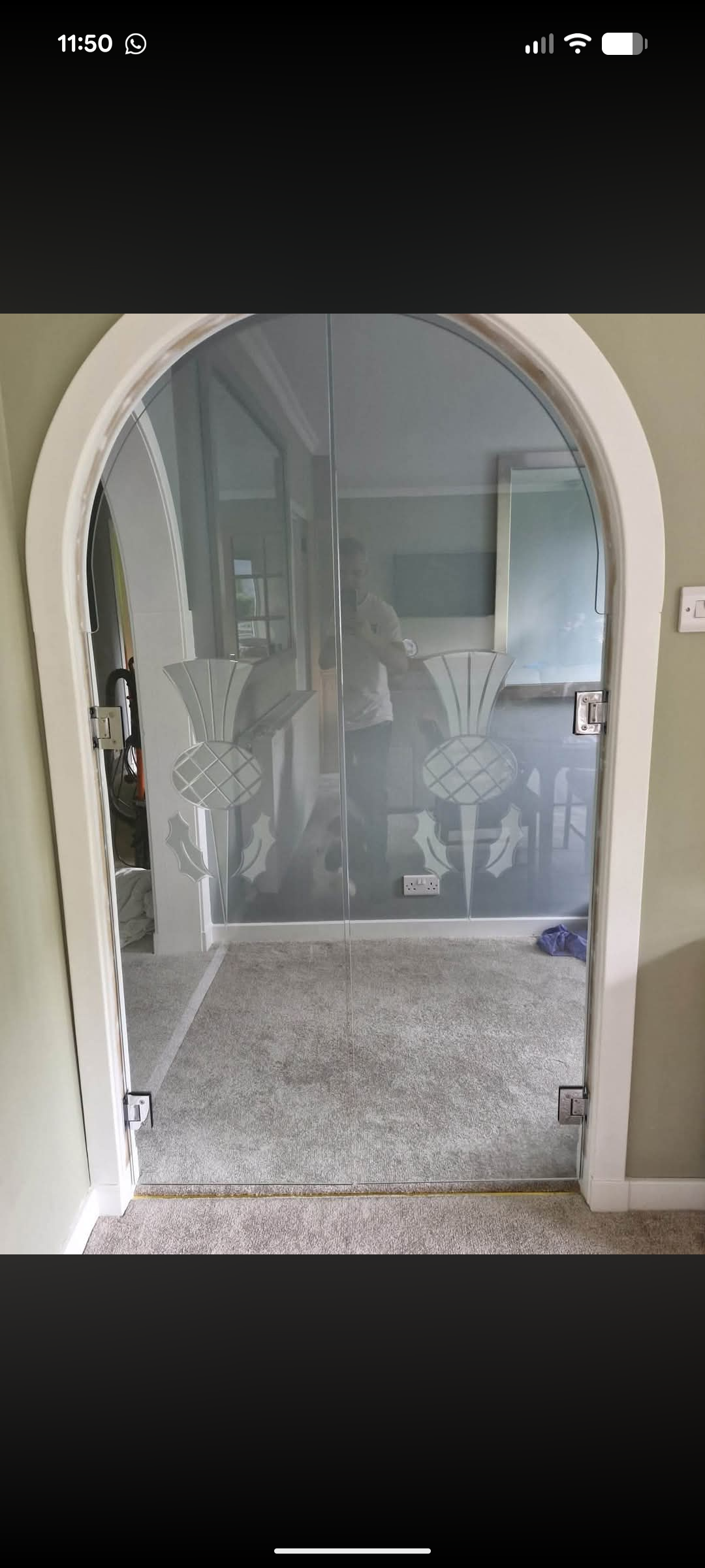 Frameless glass doors with an etched thistle design fitted into an arched doorway
