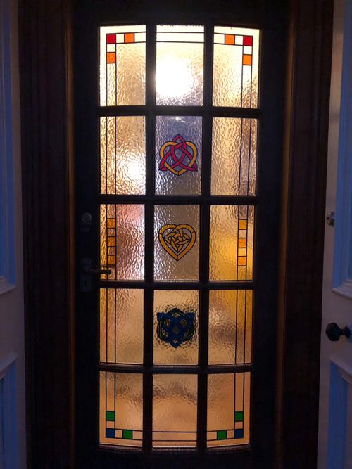 Wooden framed door with stained glass panels featuring Celtic knot designs
