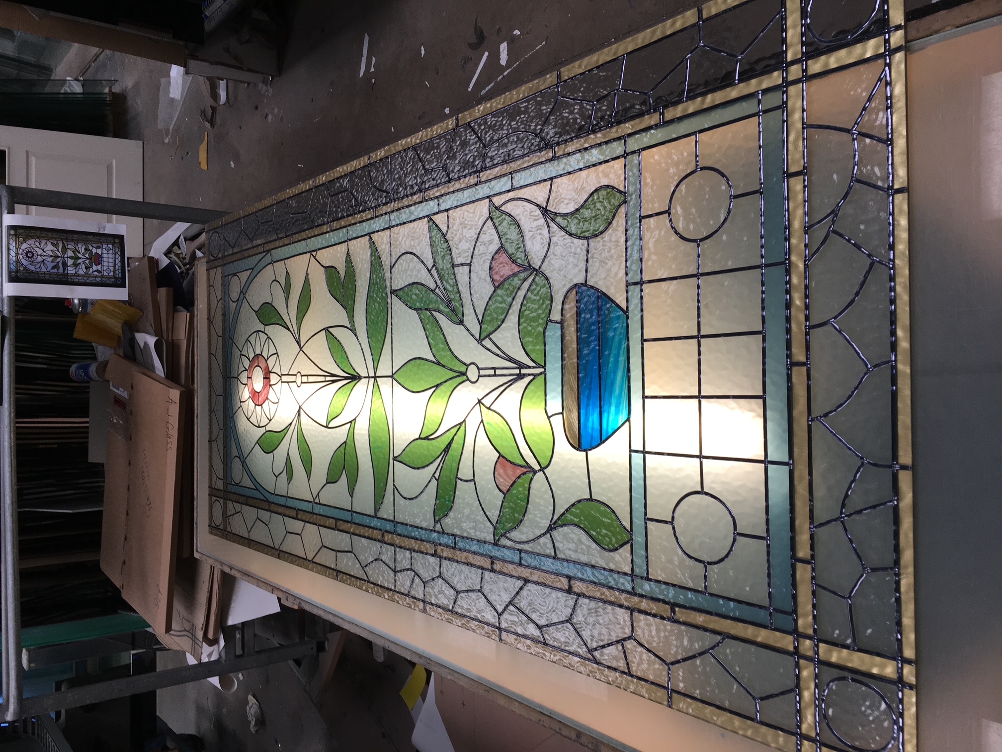 Traditional stained glass door panel with a leafy vase and flower design
